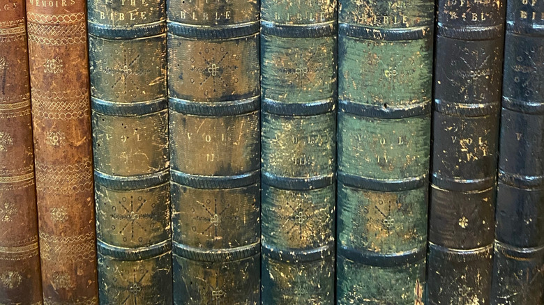 Kesilmiş kitap dikenleriyle kaplı DIY gizli kütüphane kapısında bir düğme ve anahtar delik.