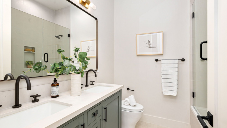 Büyük bir aynaya sahip modern bir banyo tasarımı ve makyajda iki lavabo.