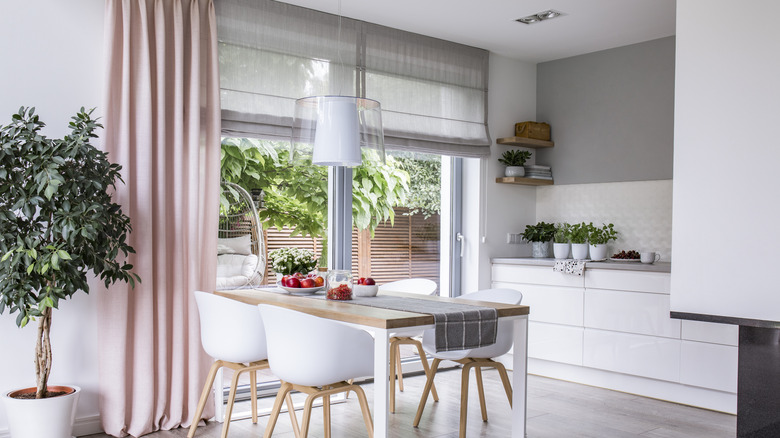 Bir yemek odasında birlikte kullanılan Roma panjurları ve perdeler