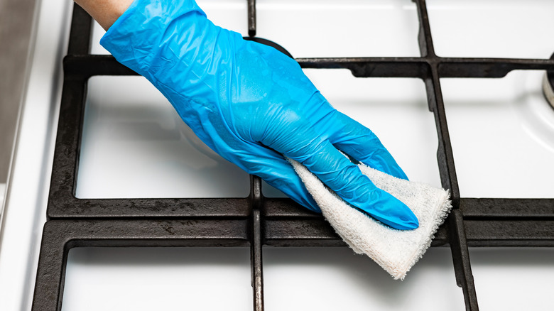 Soba ızgaralarını beyaz bir bezle silerek biri