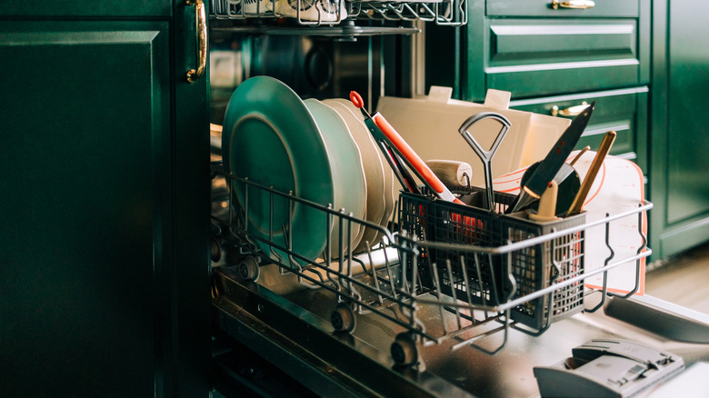 İçinde bulaşık ve çatal bıçak takımı gösteren, yıkamaya hazır bulaşık makinesi açık