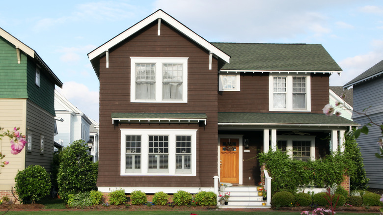 Koyu kahverengi dış boya, yeşil çatı ile ev