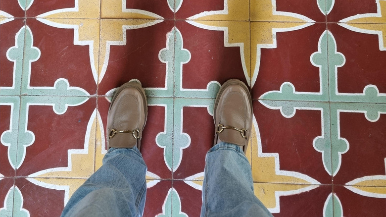 Renkli desenlerle zemin karolarında duran kişi