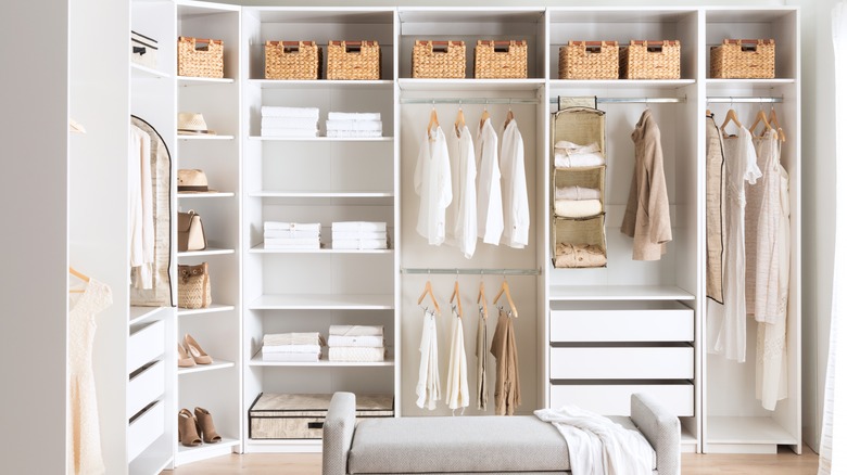 Kutu ve kıyafetli beyaz bir açık dolap.