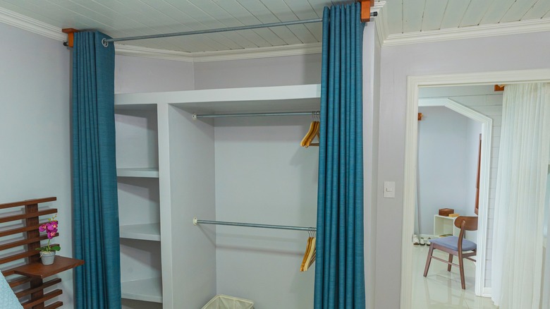 Boş bir dolabın önünde açılmış mavi bir perde.