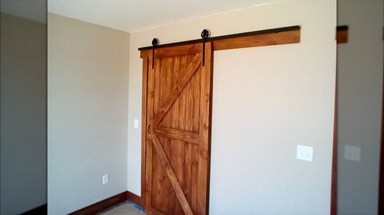 Siyah paletli kahverengi ahşap sürgülü ahır kapısı.