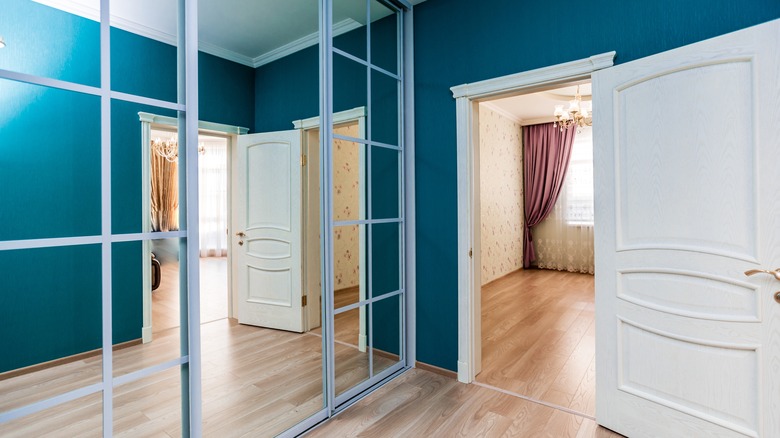 Açık bir kapının yanında yansıtılmış bir kapılı bir dolap.