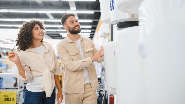 Bir mağazadaki su ısıtıcılarına bakan çift