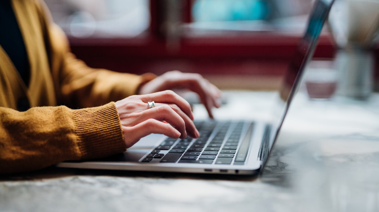 Bir dizüstü bilgisayara yazan kişi, en iyi IKEA Boaxel ürünlerine bakarak