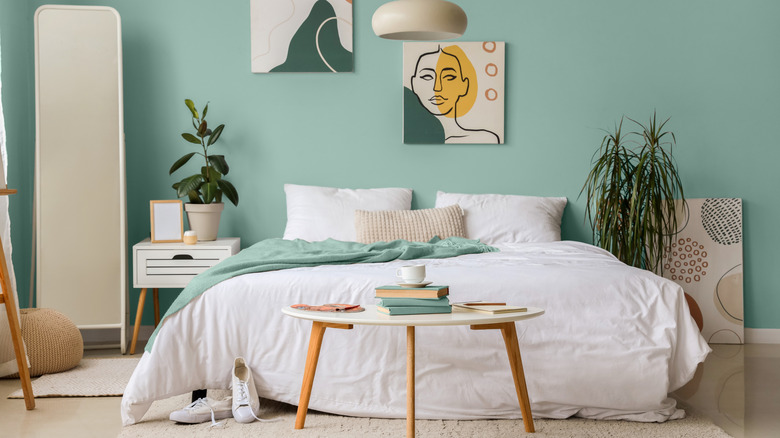 Beyaz ve doğal aksanlı turkuaz bir yatak odası.