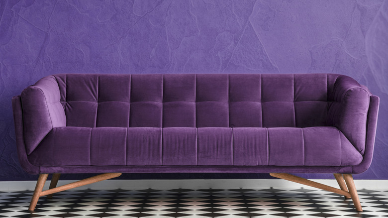 Mor kanepeli ve siyah beyaz zemine sahip mor boyalı bir oda