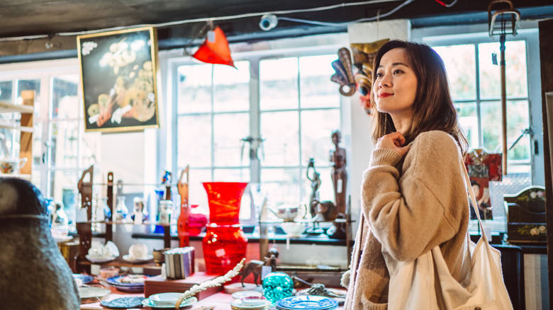 Kadın, vintage bayılan bir kanepe aramak için antika mobilya dükkanına girer.