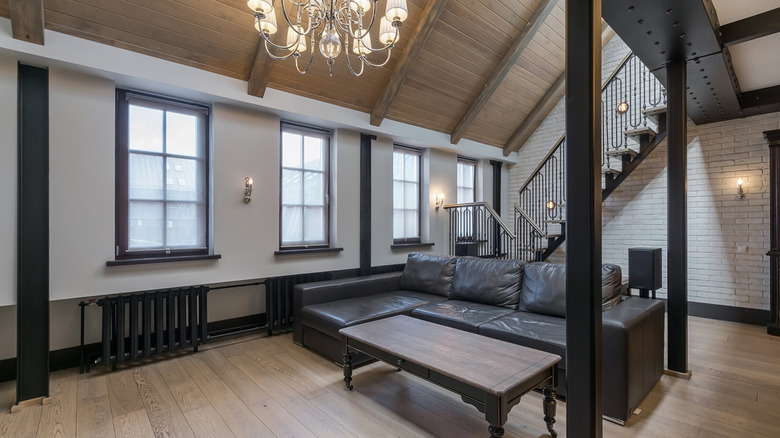 Daha hafif bir gölgede ahşap benzeri LVP döşeme ile eşleştirilmiş koyu, geleneksel ahşap döşeme ve siyah süslemeli şık oturma odası