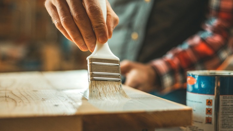 Bir masa üstüne vernik ekleyen kişi