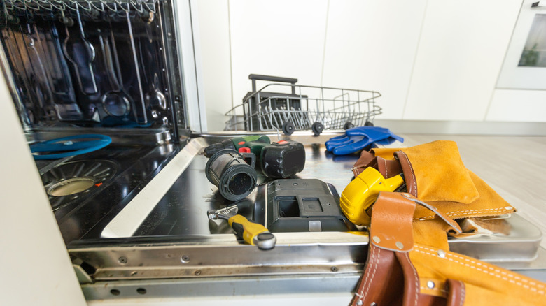 Onarımlar için açık bir bulaşık kapısında duran araçlar