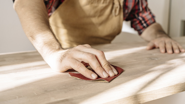 Elle bir mobilya zımparalayan bir adam