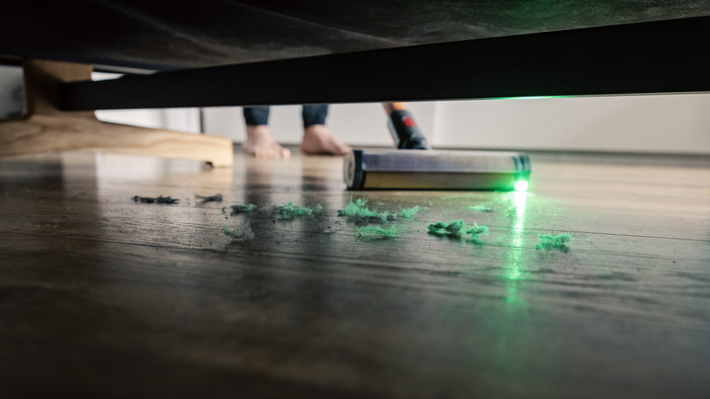 Bir yatağın altındaki tozu süpürgeli bir yatağın altındaki toz