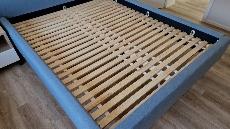 Ahşap çıtalarla mavi kumaş yatak çerçevesi