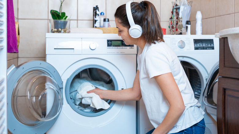 Beyaz kurutucudan çamaşır çıkaran kadın
