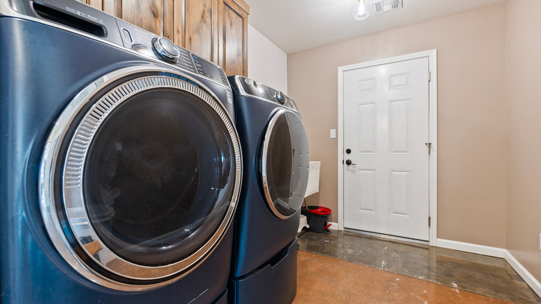 Çamaşır odasında mavi çamaşır makinesi ve kurutma makinesi