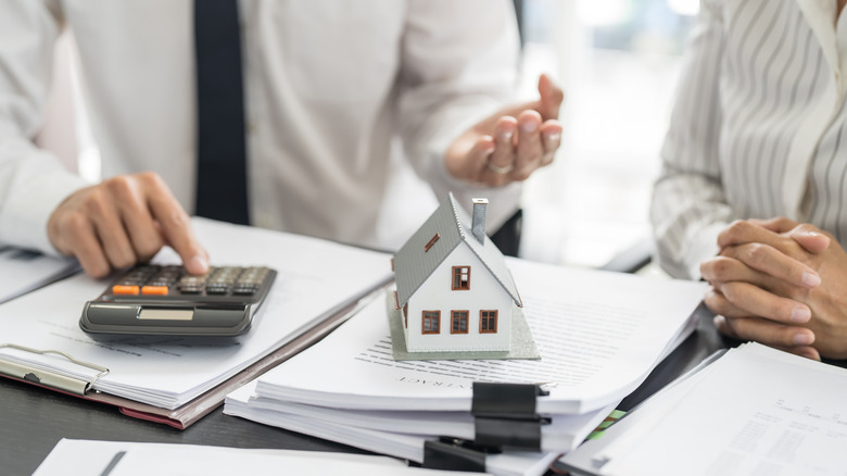 Bir yığın evrak işyerinde küçük bir model evli bir hesap makinesi kullanan kişi