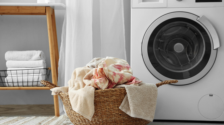 Çamaşır makinesinin yanındaki bir sepette çamaşır yıkamak