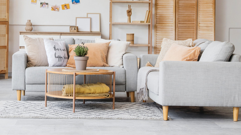 Birbirine dik açılarda oturan iki sandalyenin önüne yerleştirilmiş bir sehpa