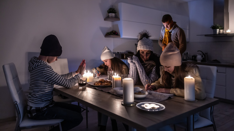 elektrik kesintisinde ışık için mumlar kullanan aile