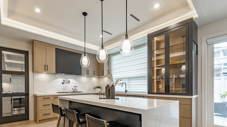 Bir mutfak adasında asılı üç modern kolye ışığı