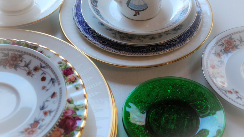 Eşleşmeyen vintage seramik ve cam plakalar yığınları.