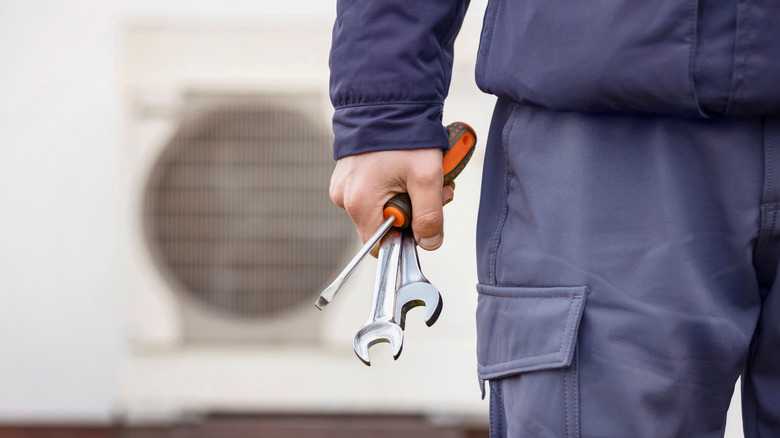 Elektrikli ısı pompası kurmak için anahtar tutan adam