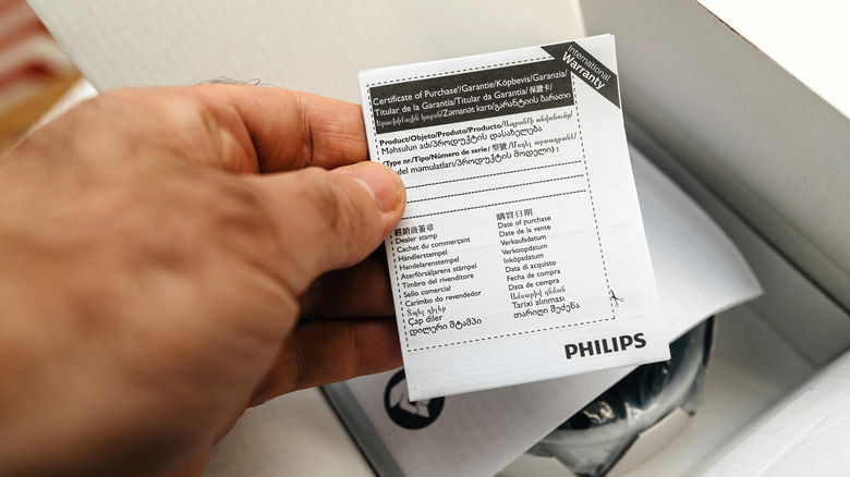 Cihazı için kağıt garantisi tutan bir adam.