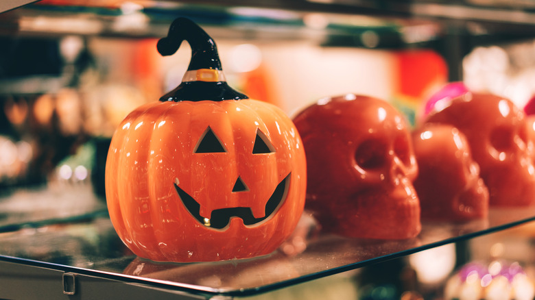 Seramik kafataslı cam rafta cadı şapkası ile seramik jack-o'-lantern