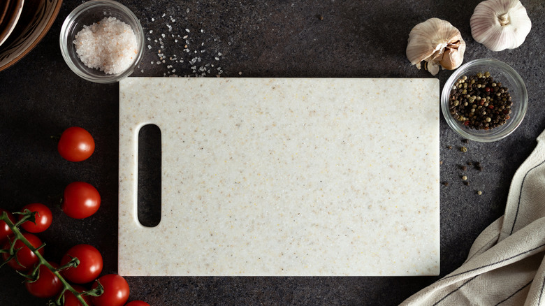 Etrafında domates, tuz, karabiber ve sarımsak ile sone kesme tahtası