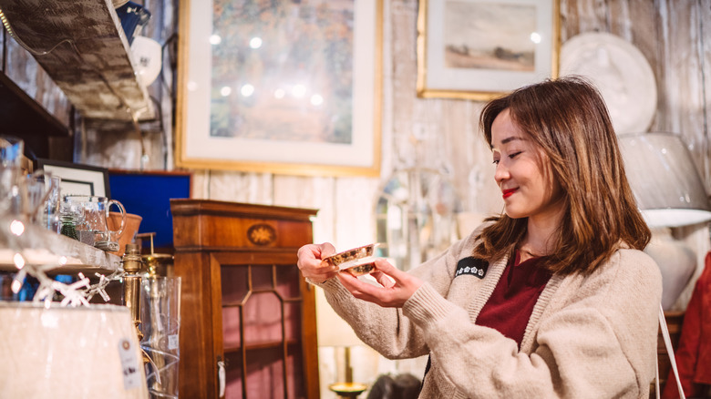 Bir antika dükkanında bir yemeğe bakan bir kadın