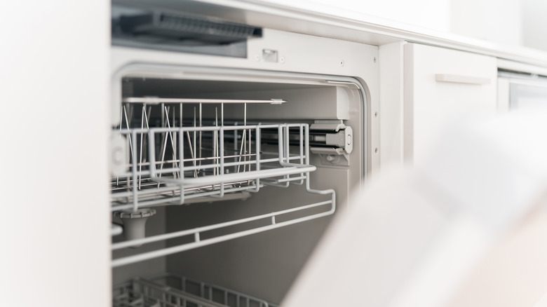 Açık bir kapılı beyaz bulaşık makinesi boş.