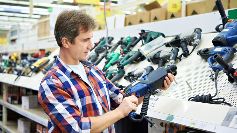 Mağazada perforatör için alışveriş yapan adam