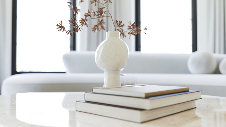 Sehpa üzerinde sonbahar yaprakları ile dolu beyaz vazo