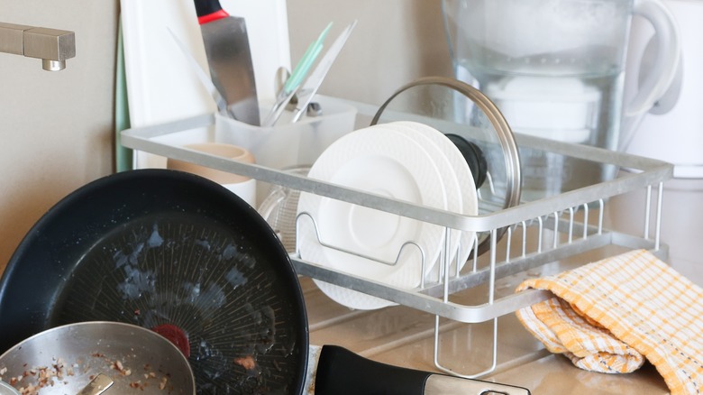 Paslanmaz çelik tabakta temiz yemeklerin yanında lavabo içinde kirli yemekler