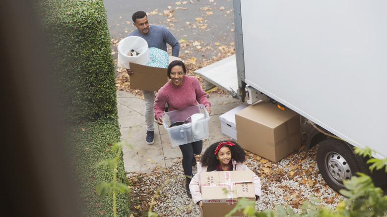 Küçük bir aile yeni evlerine kutu taşır.