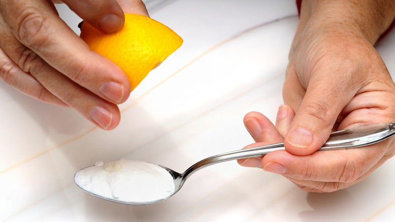 Limon ve çay kaşığı kabartma tozu tutan adam