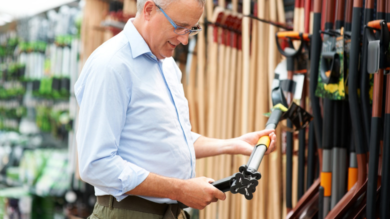 Bir mağazada bahçe aletleri için alışveriş yapan bir adam