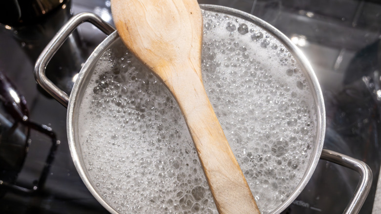 Bir tencerenin üstünde tahta kaşık kaynar su