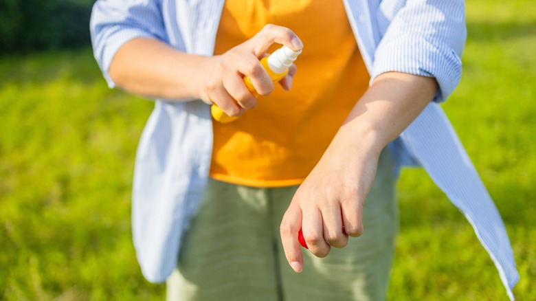 Böcek kovucu sprey açık havada kullanan kişi