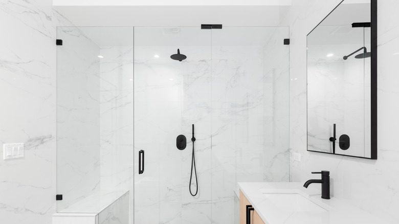 Siyah armatürler ve donanımlı beyaz banyo