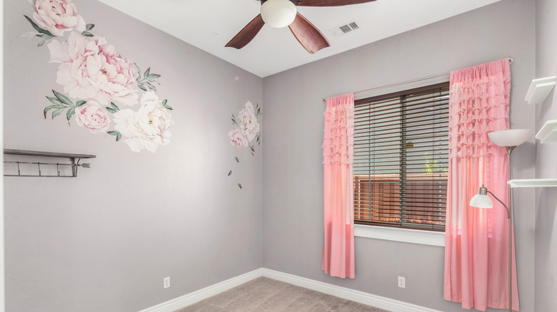 Gri bir duvarda büyük çiçek çıkartmaları