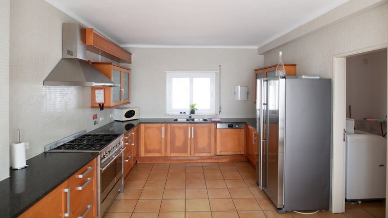 Turuncu tonlu dolapları olan modası geçmiş mutfak