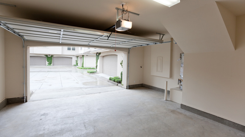 İçten dışa sokağa doğru bakan açık kapılı boş bir iki araçlık garaj, banliyö Amerika'da bir yerde pastoral bir sokak gösteriyor.