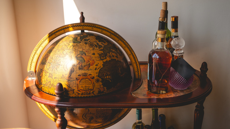 Yüzeyde alkollü vintage globe bar arabası.