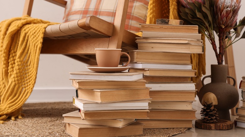 Yanında birden fazla kitap yığını olan bir sandalye,